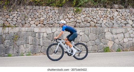 Panoramic Side View Of A Cyclist On A Mountain Road