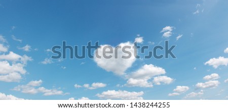 panoramic sky with flying clouds with heart shape