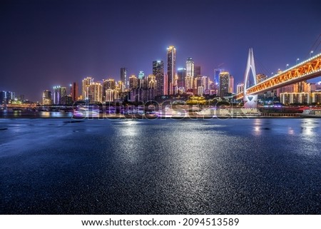 Panoramic skyline and modern commercial buildings with empty road. Asphalt road and cityscape at night.