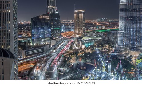 Panoramic skyline view of Dubai downtown with mall, fountains and tower aerial night timelapse with traffic. Modern illuminated skyscrapers and construction site