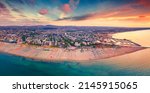 Panoramic summer view from flying drone of Libera Rimini public beach. Amazing evening scene of Italy, Europe. Stunning sunset on Adriatic coast. Vacation concept background.
