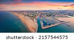 Panoramic summer view from flying drone of Libera Rimini public beach. Captivating evening scene of Italy, Europe. Colorful sunset on Adriatic coast. Vacation concept background.