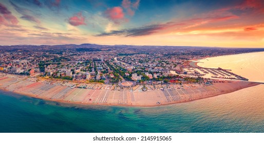 Panoramic Summer View From Flying Drone Of Libera Rimini Public Beach. Amazing Evening Scene Of Italy, Europe. Stunning Sunset On Adriatic Coast. Vacation Concept Background.
