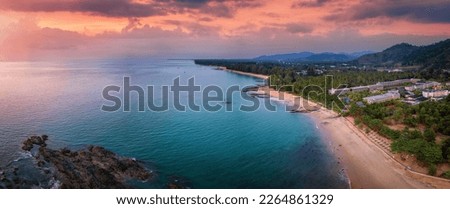 Panoramic sunset view of the beautiful coast of Khao Lak, Thailand, with turquoise sea next to fine sandy beaches and palm trees