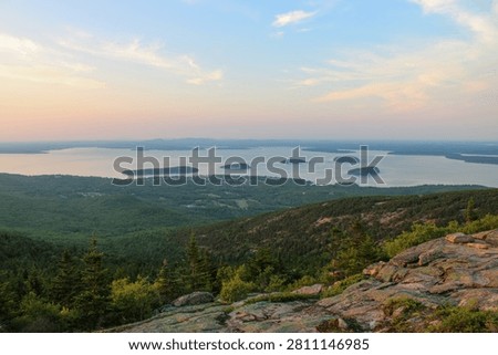 Panoramic sunset view from Cadillac Mountain overlooking Frenchman Bay and forested islands in Acadia National Park, Maine