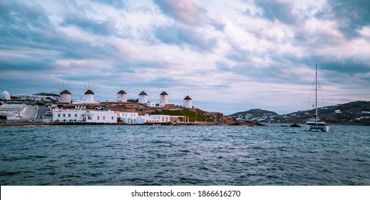 Panoramic Sunset View Of Catamaran, Windmills, And Aegean Ocean In Mykonos Town (Chora) On The Island Of Mykonos, Cyclades