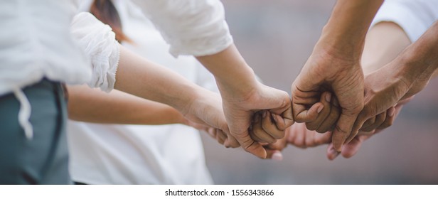 Panoramic teamwork business join hand together concept, Business team standing hands together, Volunteer charity work. People joining for cooperation success business. - Shutterstock ID 1556343866
