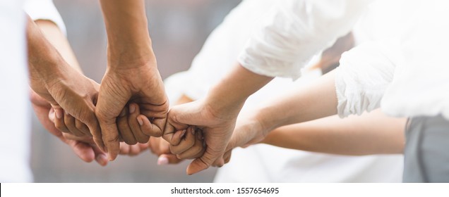 Panoramic teamwork business join hand together concept, Business team standing hands together, Volunteer charity work. People joining for cooperation success in antivirus protection. - Shutterstock ID 1557654695