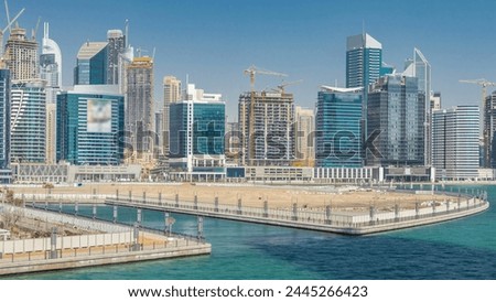 Panoramic timelapse view of business bay and downtown area with island of Dubai. Modern skyscrapers reflected in water and blue sky. Top view from bridge