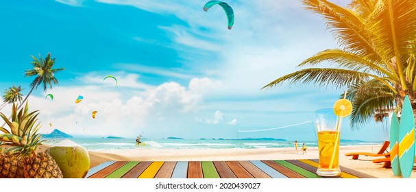 Panoramic tropical sea view. On the table are drinks and tropical fruits. A fun summer vacation getaway with outdoor activities, Kiteboarding, swimming, surfing, volleyball, and beach parties. - Powered by Shutterstock