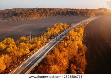 Panoramic view from above of the freeway passing through agricultural fields. The highway is the basis of the transport and logistics industry. Drone photography. Discovery the beauty of earth.
