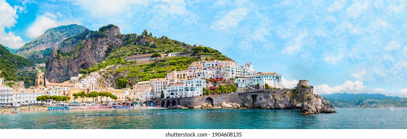 Panoramic view, aerial skyline of small haven of Amalfi village with tiny beach and colorful houses located on rock. Tops of mountains on Amalfi coast, Salerno, Campania, Italy. - Shutterstock ID 1904608135