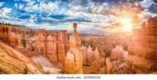 Panoramic view of amazing hoodoos sandstone formations in scenic Bryce Canyon National Park in beautiful golden morning light at sunrise with dramatic sky and blue sky, Utah, USA - Powered by Shutterstock