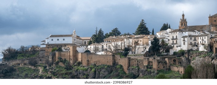 Panoramic view of an ancient hilltop town with historic buildings under a cloudy sky. - Powered by Shutterstock