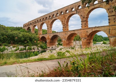 Panoramic view of ancient old Roman Aqueduct Pont du Gard ear Vers-Pon-du-Gard, Occitanie, France, Europe. Landmark over the River Gardon. Unesco world heritage site near Nimes, Languedoc-Roussillon
