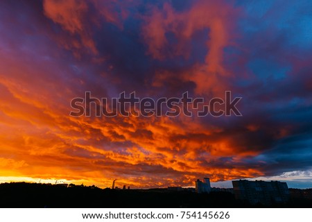 Panoramic view of apocalypse sky over city. Unbelievable nature landscape. Fantastic and outlandish stormy clouds. Warm and cold. Heaven battle. Hell and heaven fight. Colorful paysage.