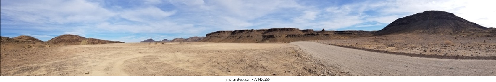 Panoramic view of Arizona desert with dirt road on side