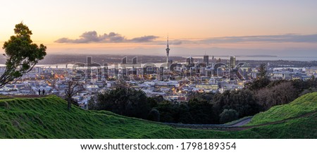 Panoramic view of Auckland city skyline with Auckland Sky Tower from Mt. Eden at sunset New Zealand