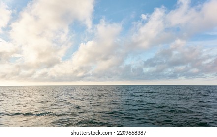 Panoramic View From The Baltic Sea Shore After The Storm. Clear Sunset Sky, Reflections, Still Water Surface Texture. Nature, Environment. Idyllic Dreamlike Seascape