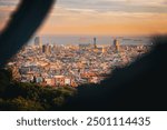 Panoramic view of Barcelona cityscape and the Mediterranean Sea from Park Güell during sunset, capturing the vibrant architecture and cultural landmarks of the city in the warm evening light.