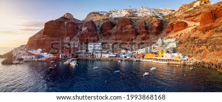 Panoramic view to the beautiful bay of Ammoudi with the restaurants and fishing boats in golden sunset light, Santorini, Greece