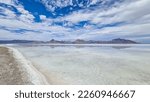 Panoramic view of beautiful mountains reflecting in lake of Bonneville Salt Flats, Wendover, Western Utah, USA, America. Looking at summits of Silver Island Mountain range. West of Great Salt Lake