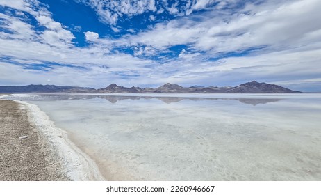 Panoramic view of beautiful mountains reflecting in lake of Bonneville Salt Flats, Wendover, Western Utah, USA, America. Looking at summits of Silver Island Mountain range. West of Great Salt Lake - Shutterstock ID 2260946667