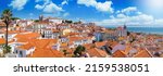 Panoramic view of the beautiful skyline of Lisbon, Portugal, with red roofed, colorful houses in the Alfama district during a sunny day