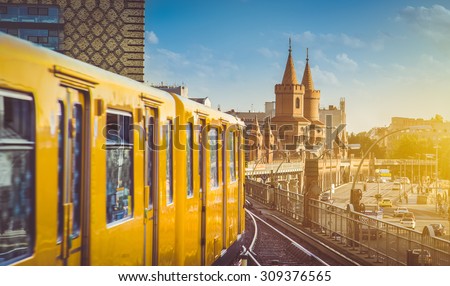 Panoramic view of Berliner U-Bahn with Oberbaum Bridge in the background in golden evening light at sunset with retro vintage Instagram style hipster filter effect, Berlin Friedrichshain-Kreuzberg