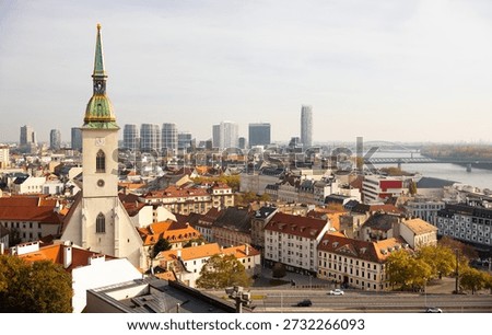 Panoramic view of Bratislava showcasing St. Martins Cathedral, Danube River, modern skyscrapers, and historic rooftops on autumn day, Slovakia