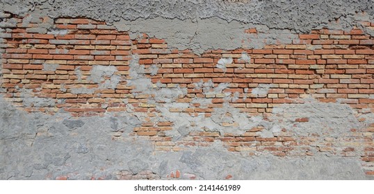 Panoramic view of the brickwork. Brick wall with peeling concrete plaster as background.