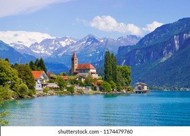 Panoramic view to the Brienz town on lake Brienz by Interlaken, Switzerland. Old fishing town with beautiful church and snow covered Alps mountains on background. Switzerland, Europe. - Shutterstock ID 1174479760
