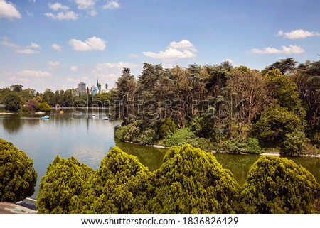 Panoramic view of Chapultepec public park or forest, 2nd section, and one of its minor lakes, Mexico City skyline.