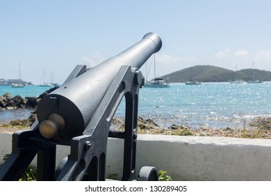 Panoramic view of Charlotte Amalie harbor with old cannon in foreground