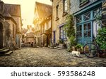 Panoramic view of a charming street scene in an old town in Europe in beautiful evening light at sunset with retro vintage Instagram style pastel toned filter and lens flare sunlight effect in summer