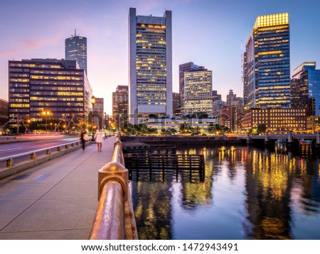Panoramic view of the city of Boston in Massachusetts, USA at night showcasing its mix of contemporary and historic architecture by Seaport Boulevard.
