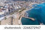 Panoramic view of the city of Civitavecchia with the adjoining tourist port and Forte Michelangelo. Emerald sea and view with tropical palm trees. Ferris wheel and cloudy sky.