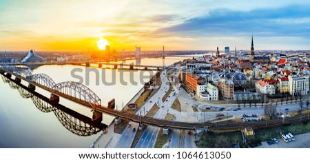 Panoramic view of city Riga,Latvia during late evening sunset. Old railway bridge in foreground. 