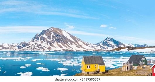 Panoramic view of colorful Kulusuk village in East Greenland - Kulusuk, Greenland - Melting of a iceberg and pouring water into the sea - Powered by Shutterstock