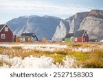 Panoramic view of colorful village in East Greenland.
Houses in the small village during summer sunny day. Icebergs and mountains in the background. Typical buildings for Greenland. Romantic landscape