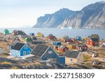 Panoramic view of colorful village in East Greenland.
Houses in the small village during summer sunny day. Icebergs and mountains in the background. Typical buildings for Greenland. Romantic landscape