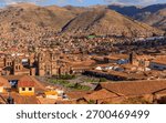 Panoramic view of Cusco, Peru, showcasing historic architecture and surrounding mountains under a clear blue sky.