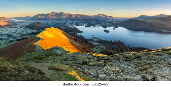 Panoramic view of Derwentwater in the Lake District with warm morning light illuminating Catbells.