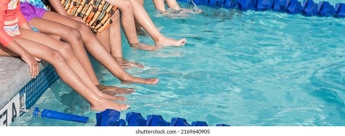 Panoramic view diverse children resting sitting at poolside of swimming class in North Texas, America. Multiethnic group of kids with swimwear at swimming pool class learning to swim - Powered by Shutterstock