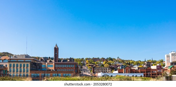 Panoramic view of downtown in autumn season with clear blue sky, view of transportation from the hill to the city. Daytime sightseeing of buildings and nature landscape. Skyline scenic with copy space