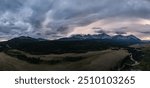 A panoramic view of a dramatic stormy sky over the mountains in Alberta, Canada. The clouds create a breathtaking and powerful landscape scene as the sun sets.