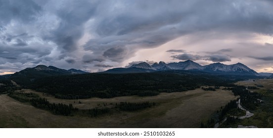 A panoramic view of a dramatic stormy sky over the mountains in Alberta, Canada. The clouds create a breathtaking and powerful landscape scene as the sun sets. - Powered by Shutterstock