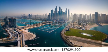 Panoramic view of Dubai Marina skyscrapers and JBR beacg with luxury buildings and resorts in one of the United Arab Emirates travel spots and resorts in Dubai aerial view