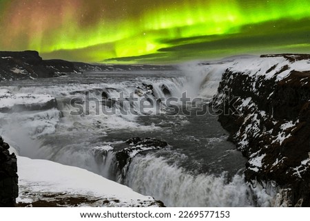 Panoramic view during Aurora Borealis or Northern Lights over the Gullfoss waterfall in the Hvita River flowing from Hvitarvatn Lake and the Langjokull Glacier in Iceland