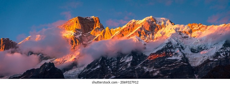 Panoramic view during sunset over snow cladded Kedarnath mountain peaks falls in Gangotri Himalayan mountain range from Kedarnath temple, Rudraprayag, Uttarakhand, India.